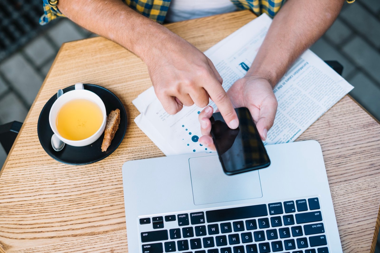 Propriétaire consultant son téléphone pour contacter Booking.com via l'Extranet