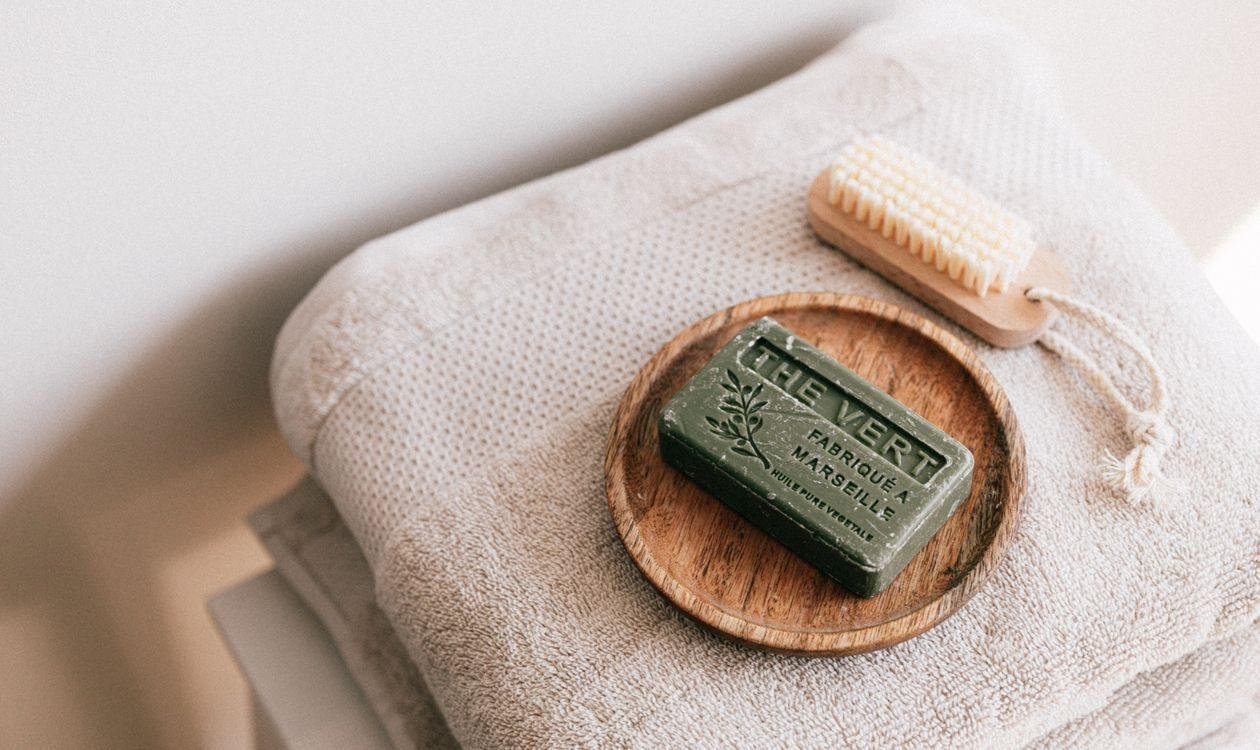 Savon naturel posé sur une pile de serviettes propres pliées